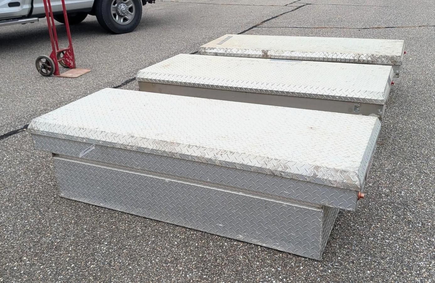 White padded benches on a paved outdoor lot