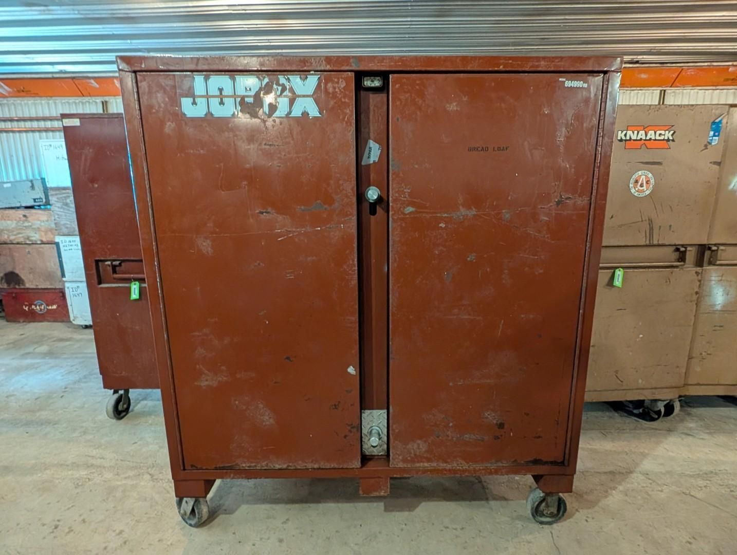 brown industrial storage cabinet on casters in a warehouse, with boxes stacked behind it