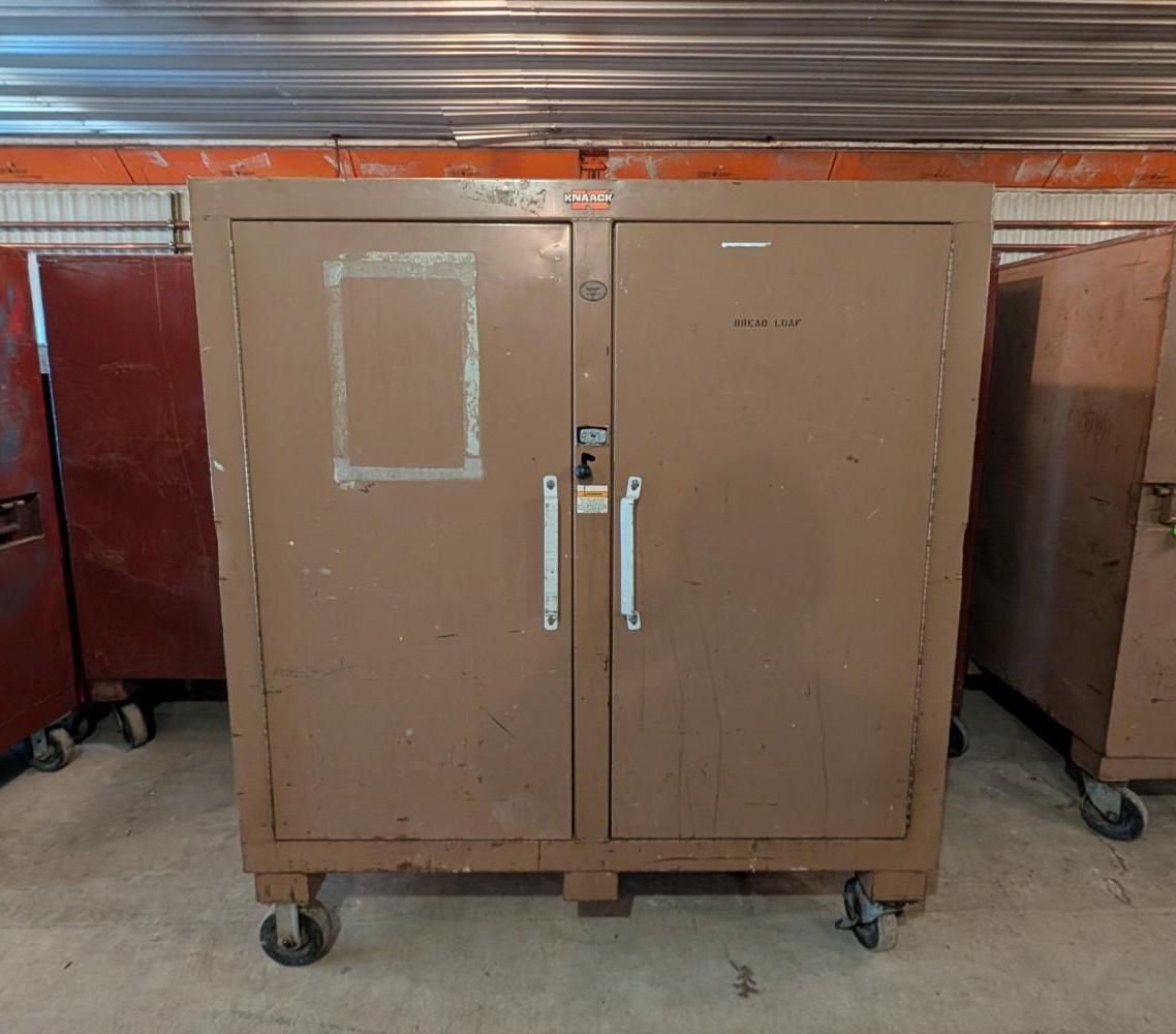 Brown metal storage cabinet on wheels in a workshop or storage area