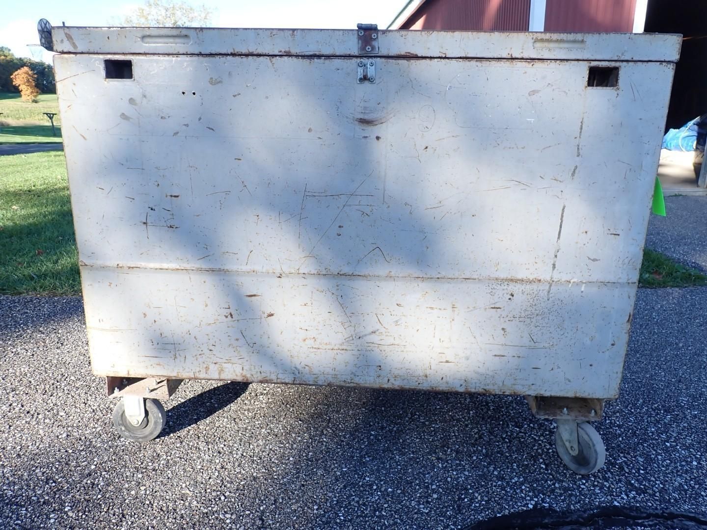 Large white metal dumpster on wheels outdoors in sunlight