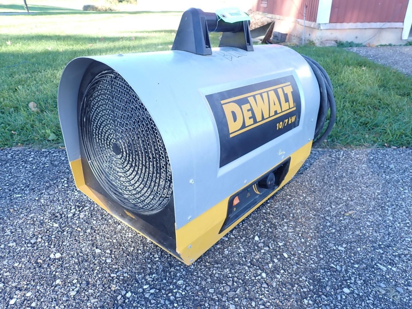 Yellow and black DeWalt portable electric fan heater on gravel outdoors