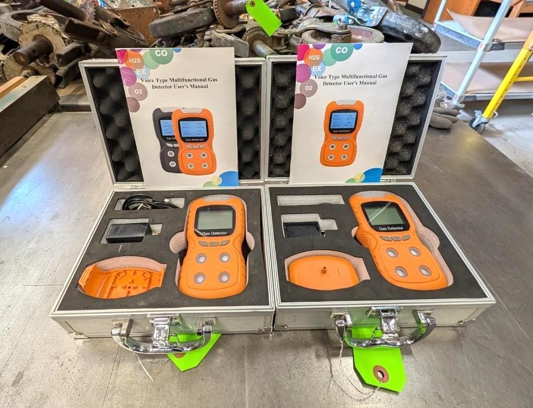 Open cases with orange handheld scanners and accessories on a workbench