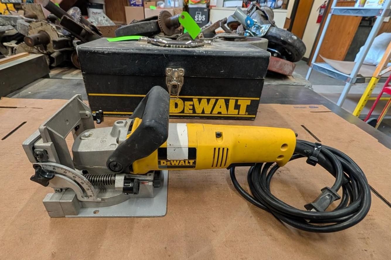 DeWalt yellow and black biscuit joiner with cord beside a black DeWalt case on a workbench