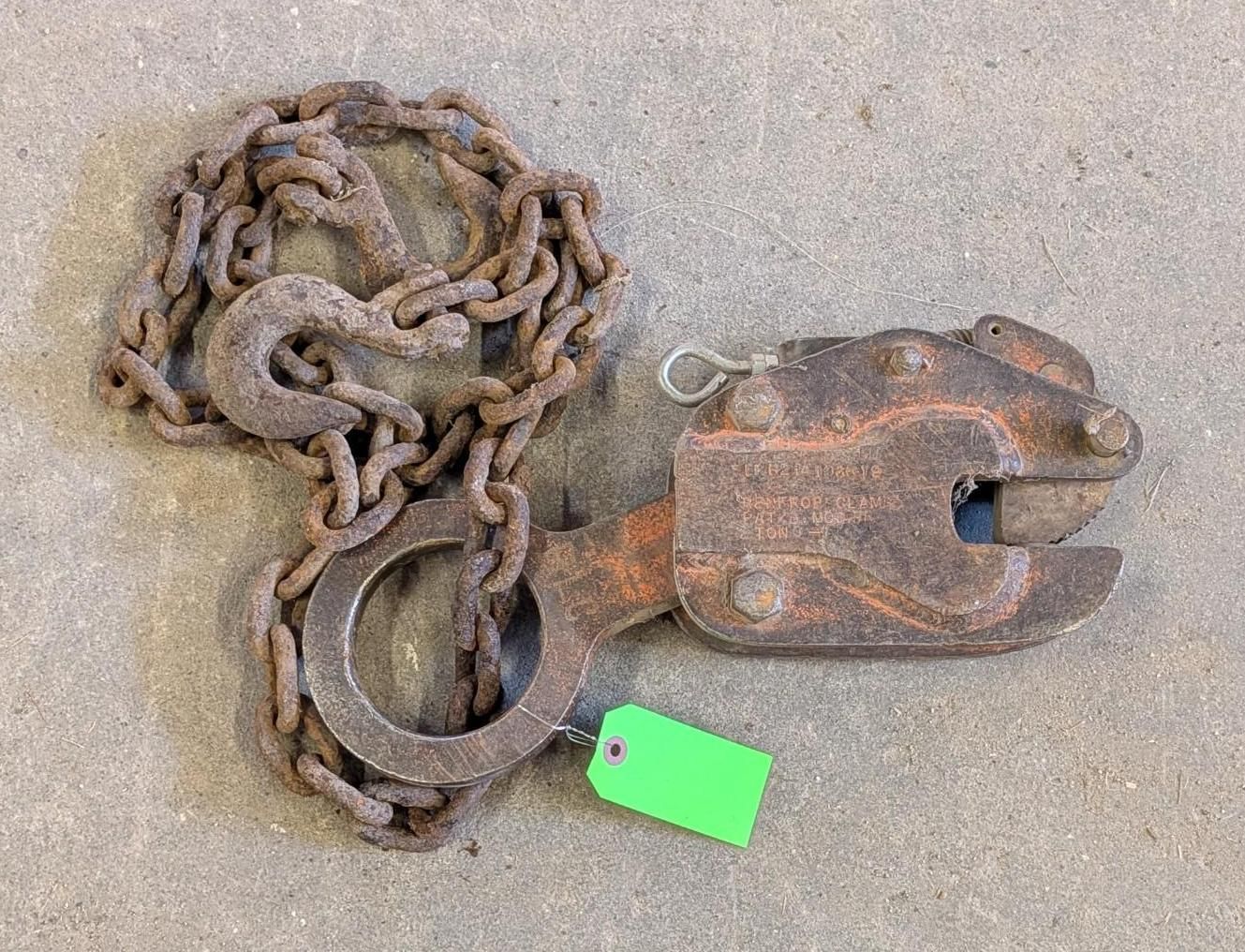 chain with large metal hook and green tag on a concrete surface