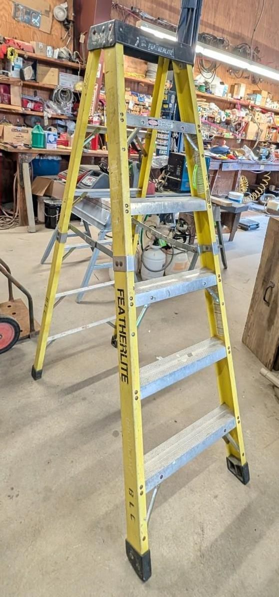Yellow step ladder in a store aisle with tools and supplies in the background