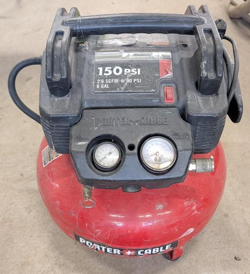 Red Porter-Cable air compressor with gauges and handle, sitting on a floor.