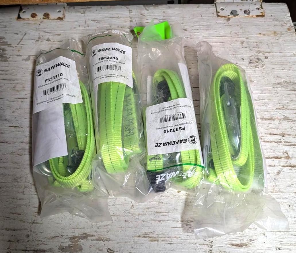 Four neon green cable harnesses in clear plastic bags on a white wooden surface