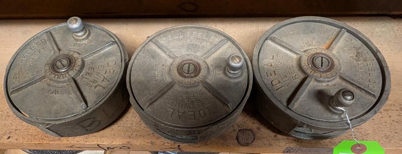 Three round metal lids or pans with knobs, arranged side by side on a wooden surface.