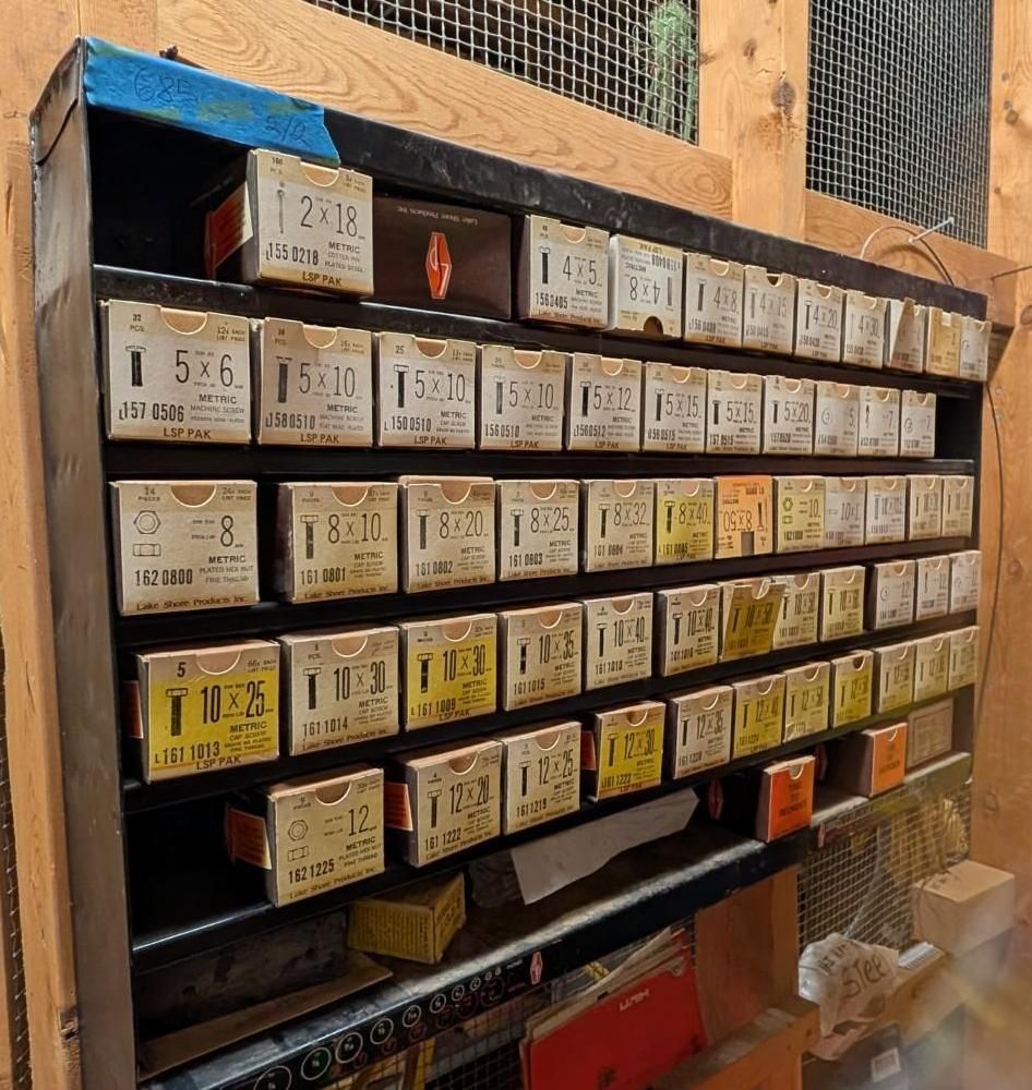 Rows of labeled lockers or mail slots in a wooden wall display inside a shop or temple-like setting