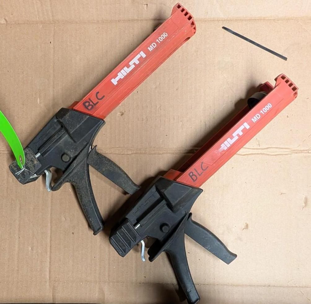 Two red-and-black Hilti BLC tools on cardboard