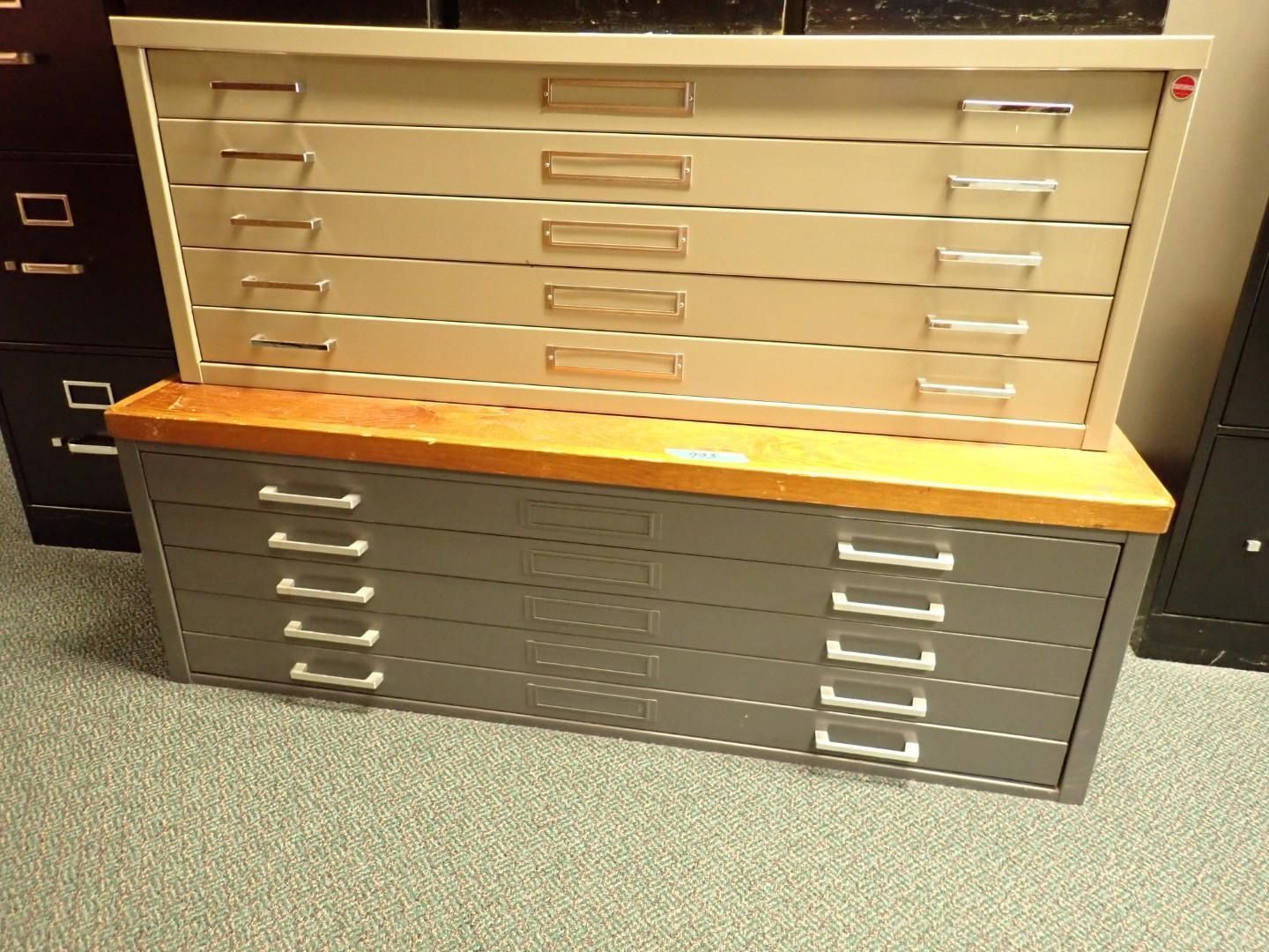 Wooden-topped gray storage cabinets with multiple drawers in a carpeted room