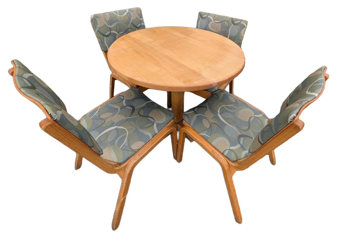 Wooden round table with four cushioned chairs in a star-shaped arrangement