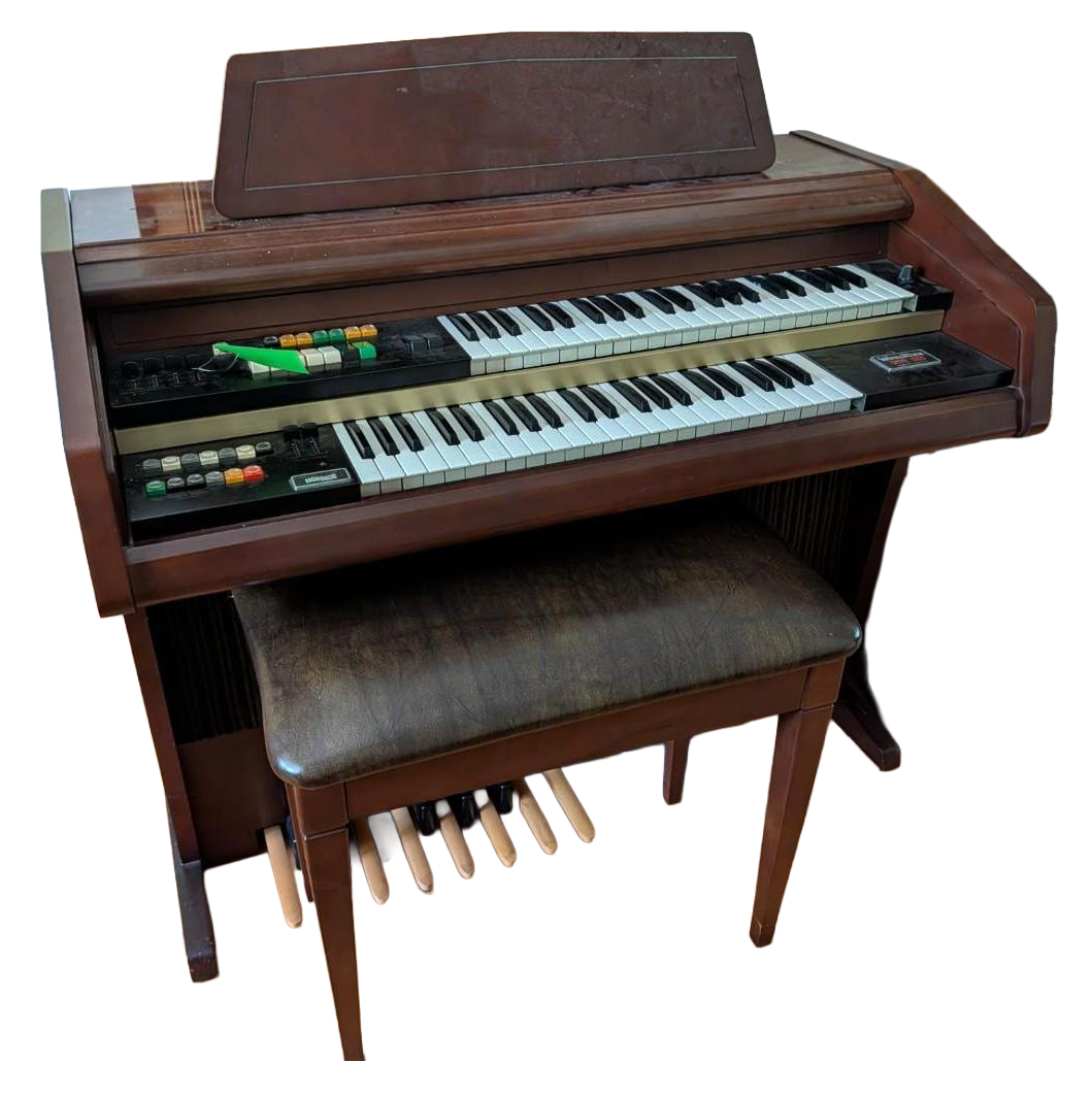 Brown electric organ with dual keyboards, foot pedals, bench, and music stand