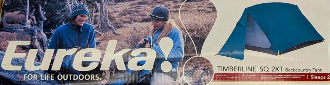 Eureka camping ad with two campers and a blue tent in a winter forest setting