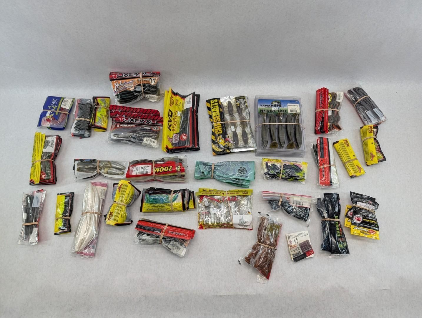 Assorted fishing lures in colorful wrappers scattered on a white surface.