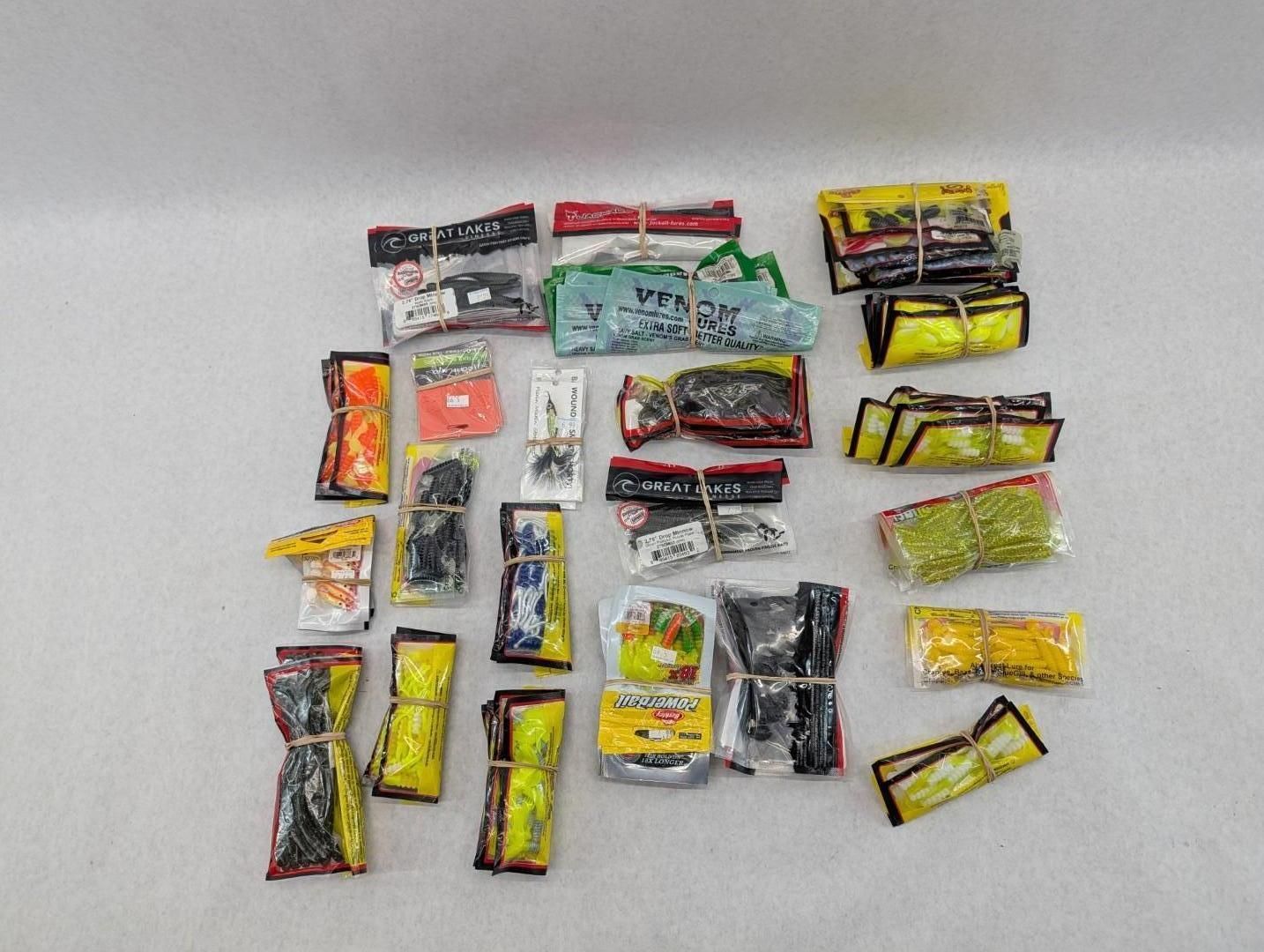Assorted packaged fishing lures arranged on a white surface.
