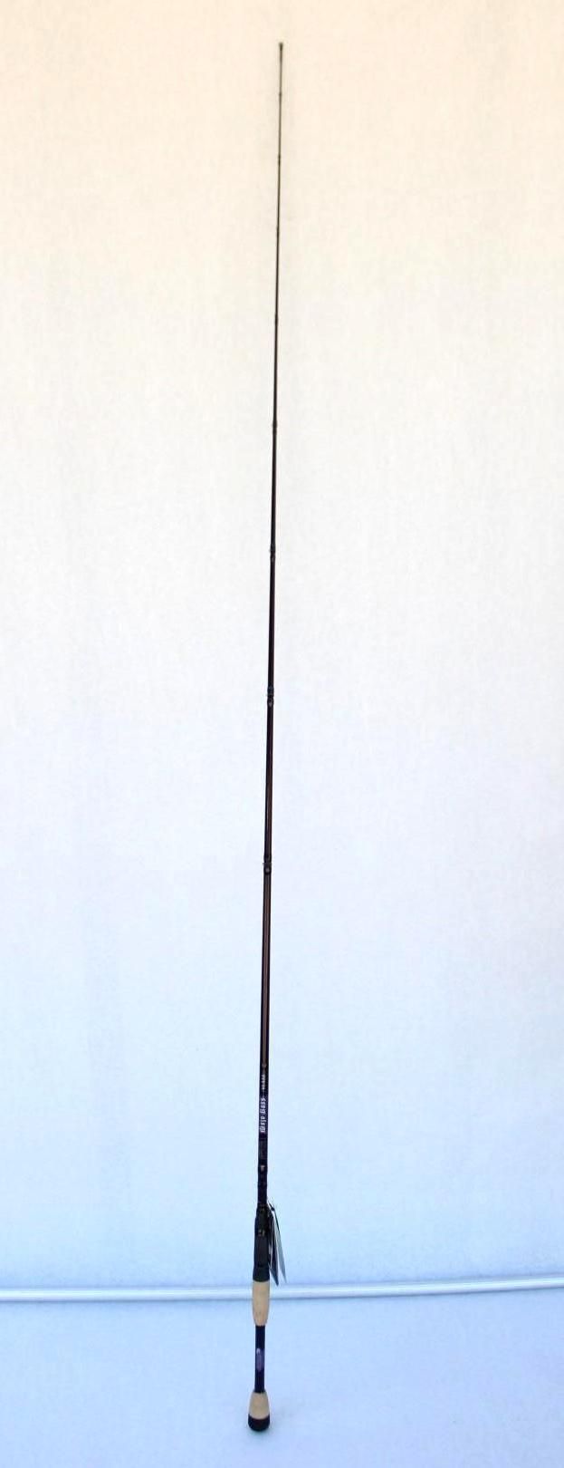 Tall black fishing rod standing upright against a plain light wall