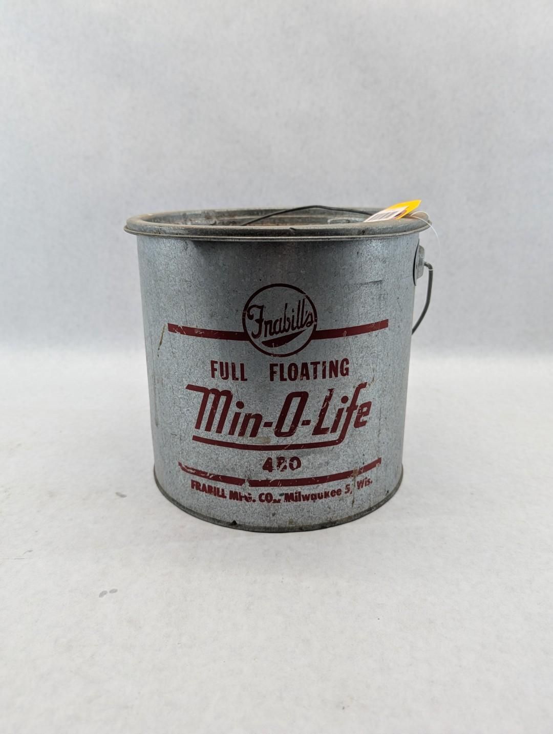 Gray paint bucket labeled “Tin-O-Lite” with an open top and yellow handle on a white background