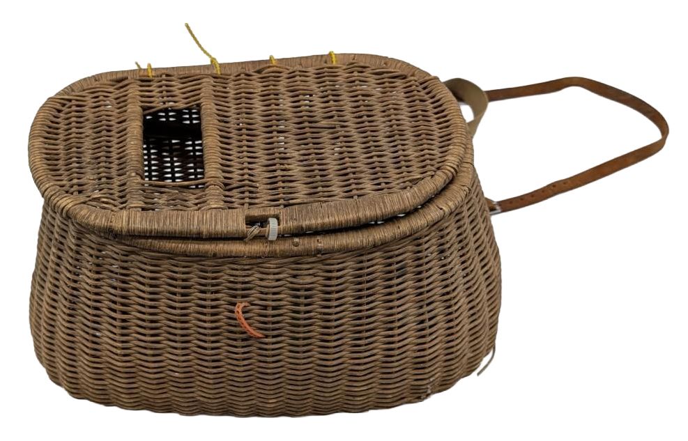 Brown woven wicker basket with a lid and shoulder strap on a white background