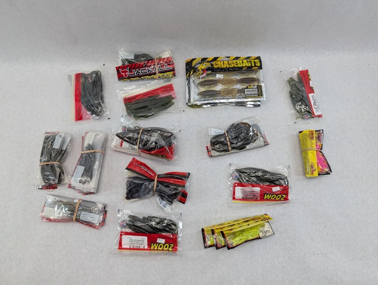 Assorted small fishing lure packages in red, yellow, silver, and black wrappers on a white surface