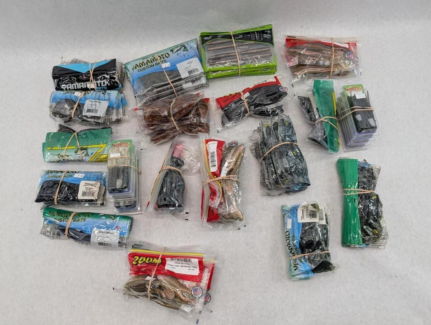 Assorted fishing lure packs arranged on a white surface.
