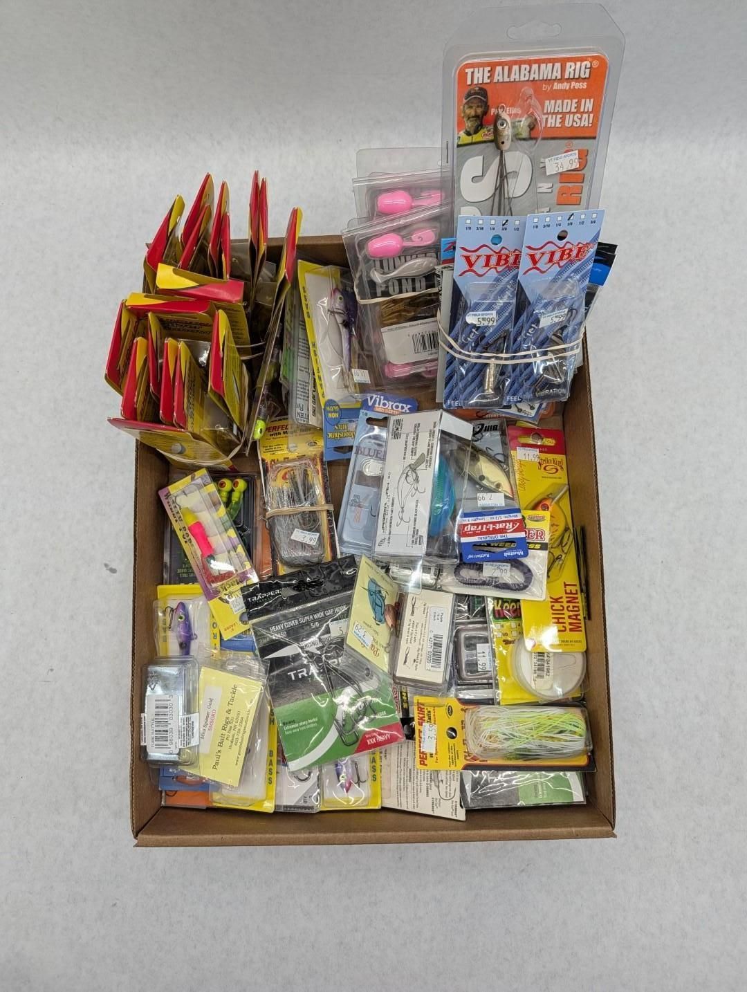 Assorted fishing lure packages arranged in a cardboard display tray on a table.