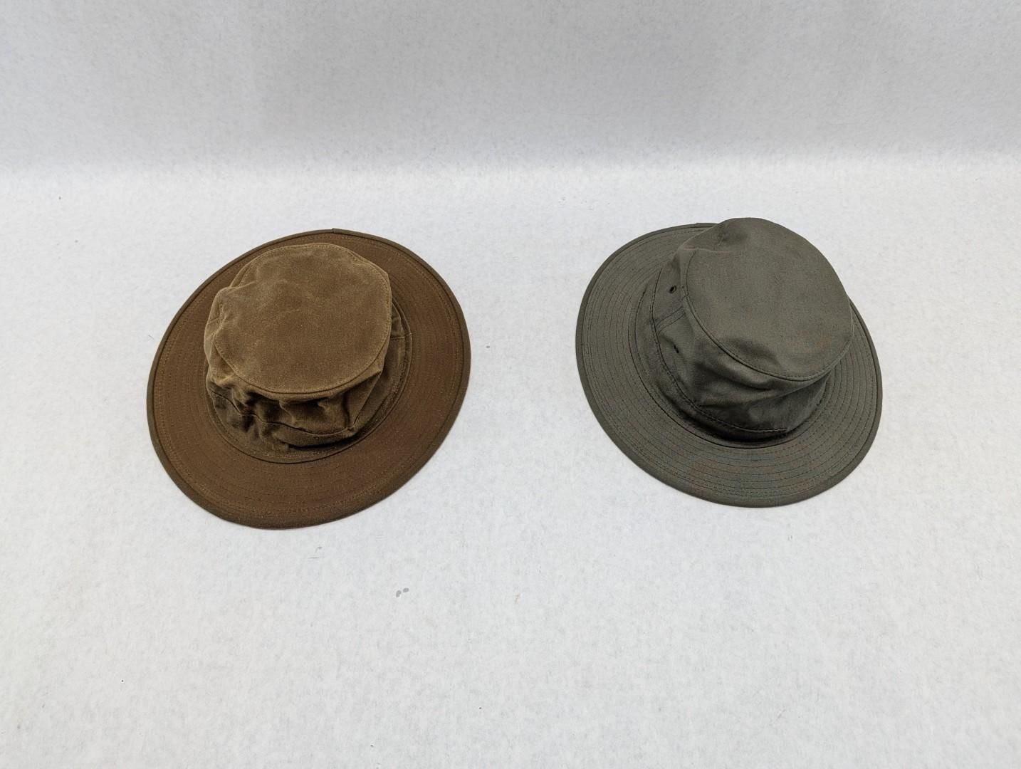 Two hats, one brown and one gray, on a white background