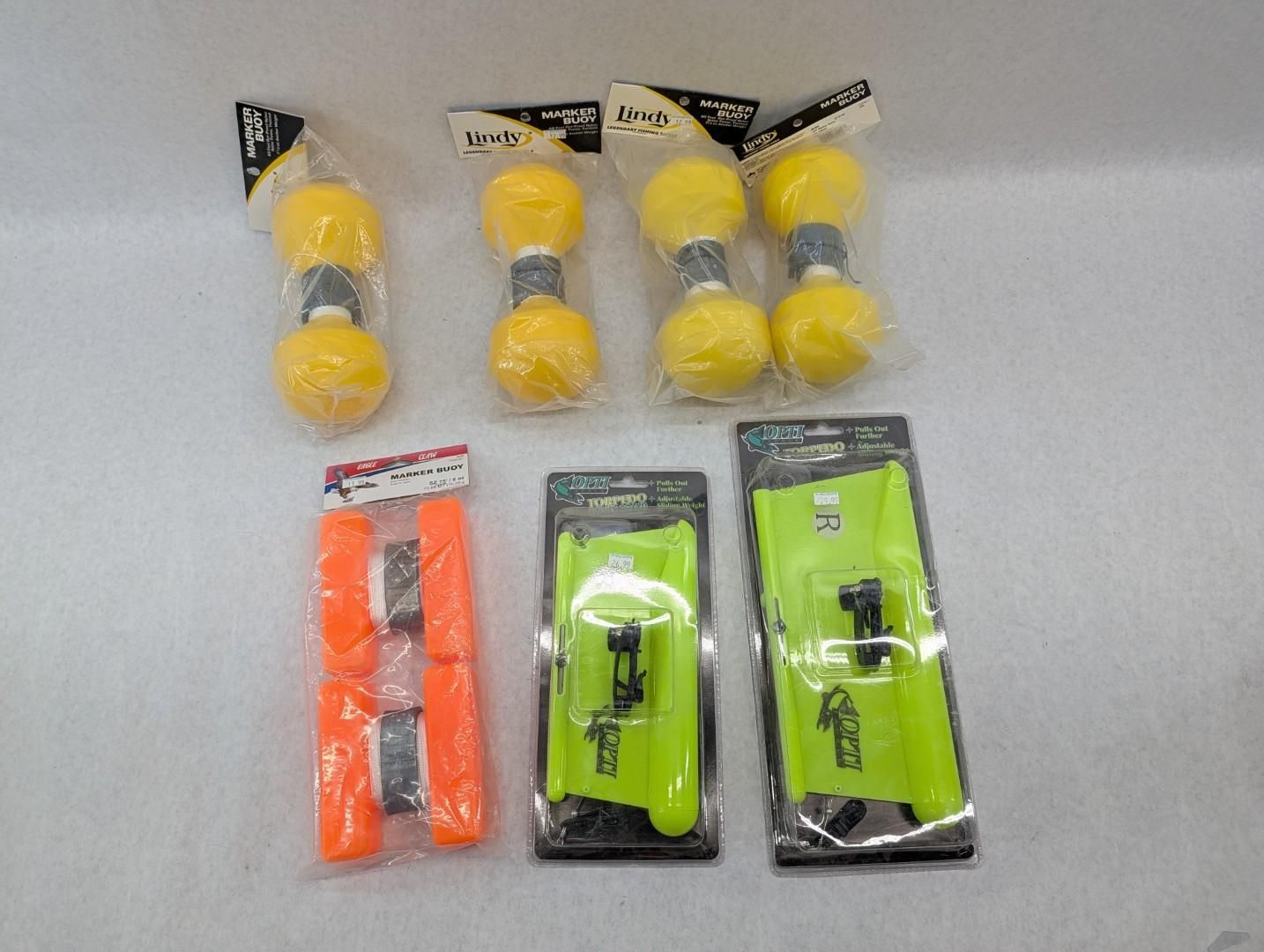 Assorted packaged fishing accessories in yellow, orange, and green on a light surface
