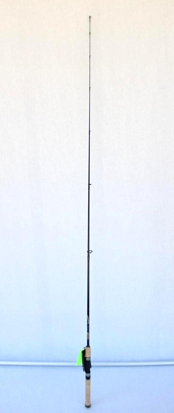 Fishing rod standing upright against a plain white wall