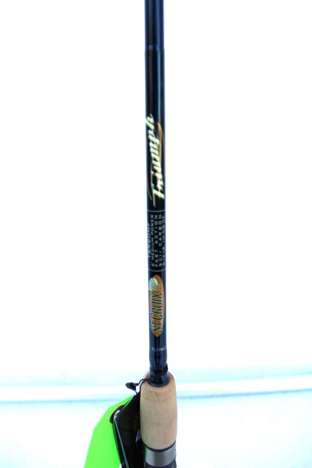 Close-up of a black fishing rod with a cork handle against a white background