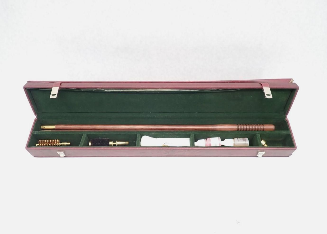 Open green-lined case containing gun accessories