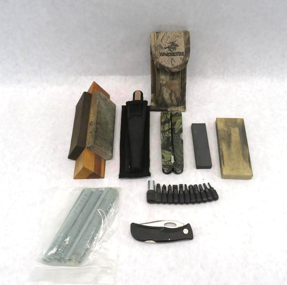 Assorted tools and sharpening stones arranged on a white background