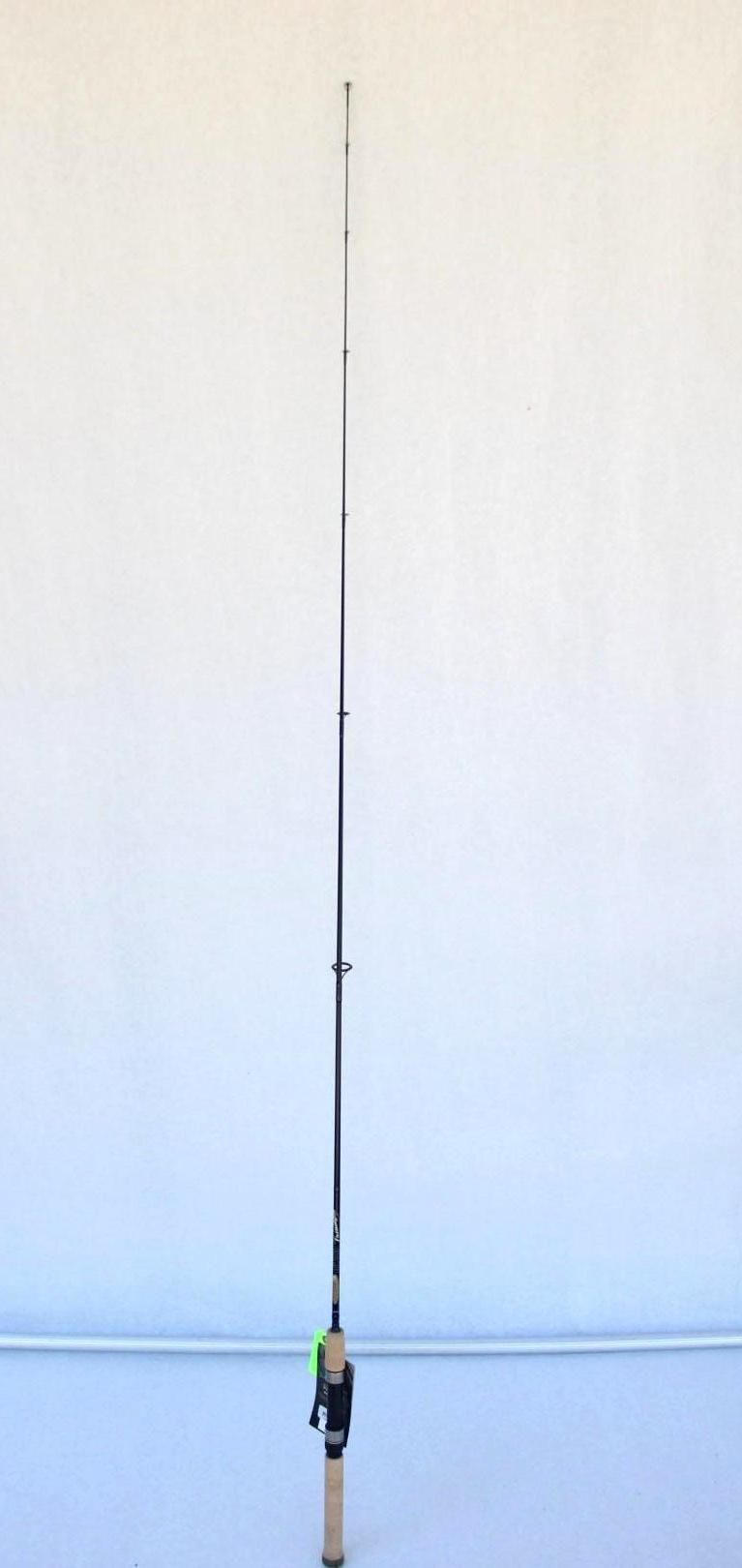 Fishing rod standing upright with a line extending upward against a plain wall background