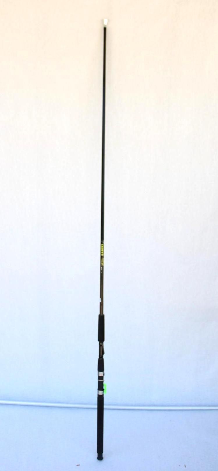 Black fishing rod standing upright against a plain white wall.