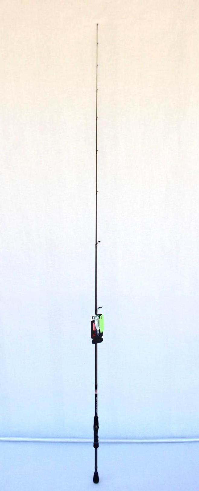Fishing rod standing upright against a plain wall.