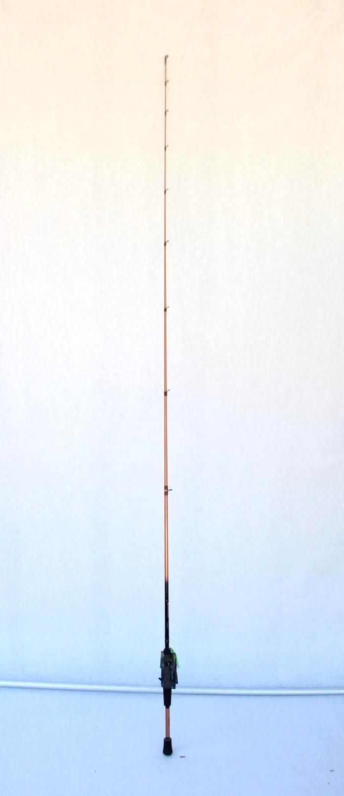Tall fishing rod standing upright against a plain light wall and floor.