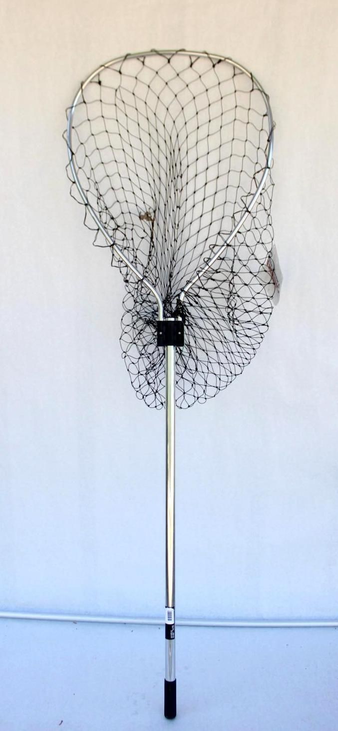 Fishing landing net with long handle standing upright against a white wall