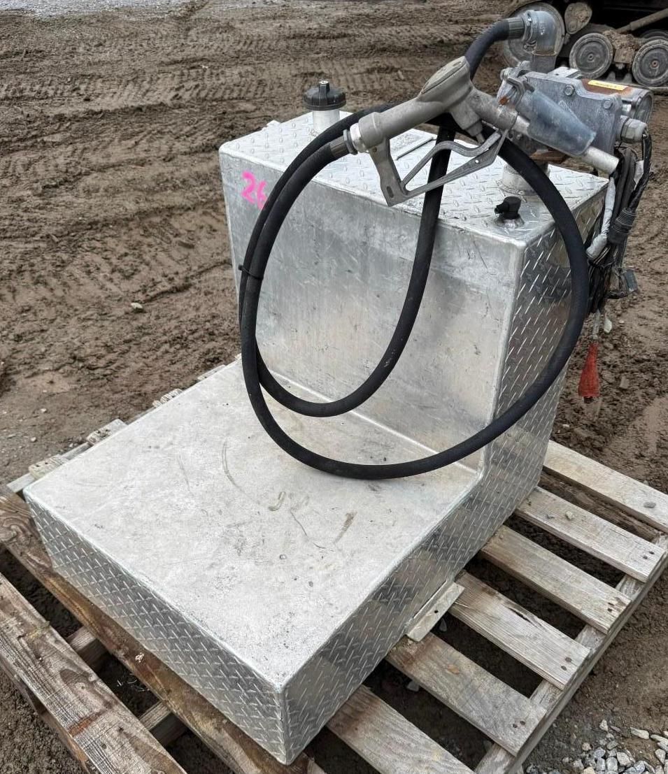 Hydraulic jack on a concrete block atop a wooden pallet at a dirt construction site