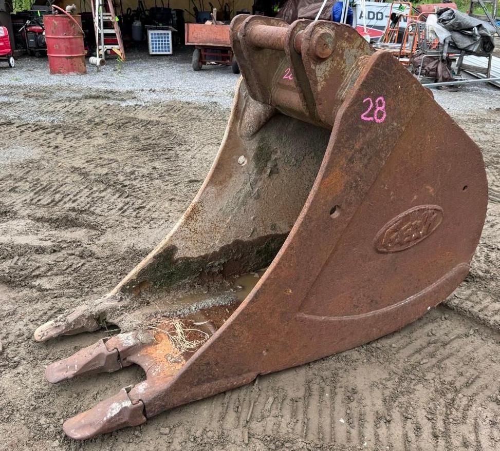 excavator bucket attachment on ground at an outdoor worksite.