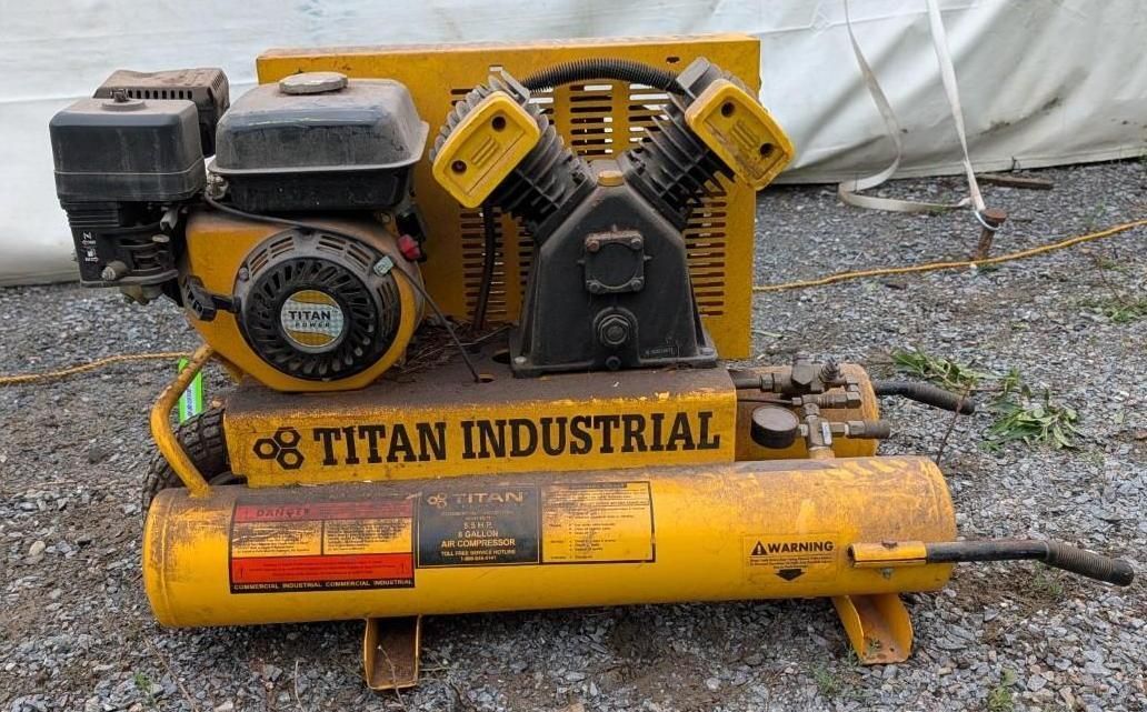 Yellow Titan Industrial air compressor on gravel, with engine and tank visible.