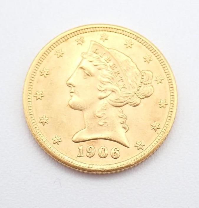 1906 gold coin with Liberty profile and stars on a plain white background