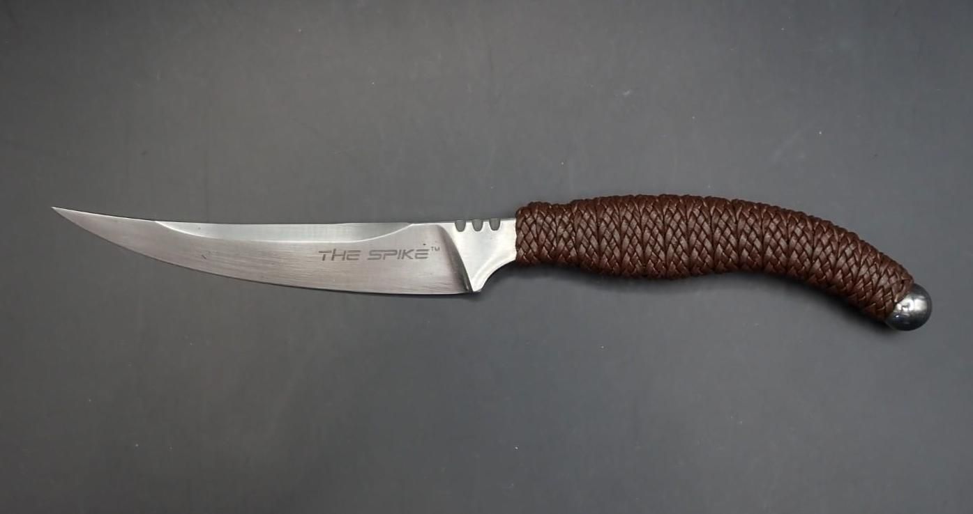 Stainless steel knife with curved blade and brown textured handle on a gray background