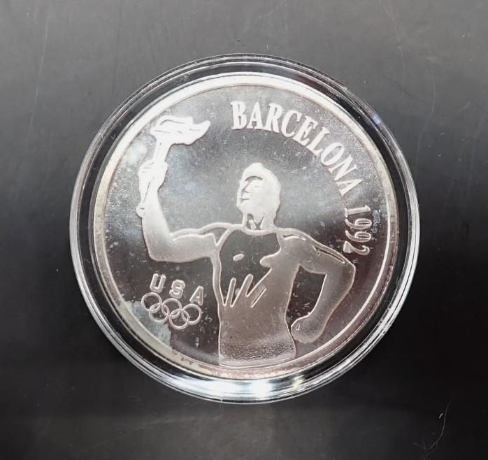 Barcelona 1992 Olympic silver coin with a gymnast and Olympic rings on a black background