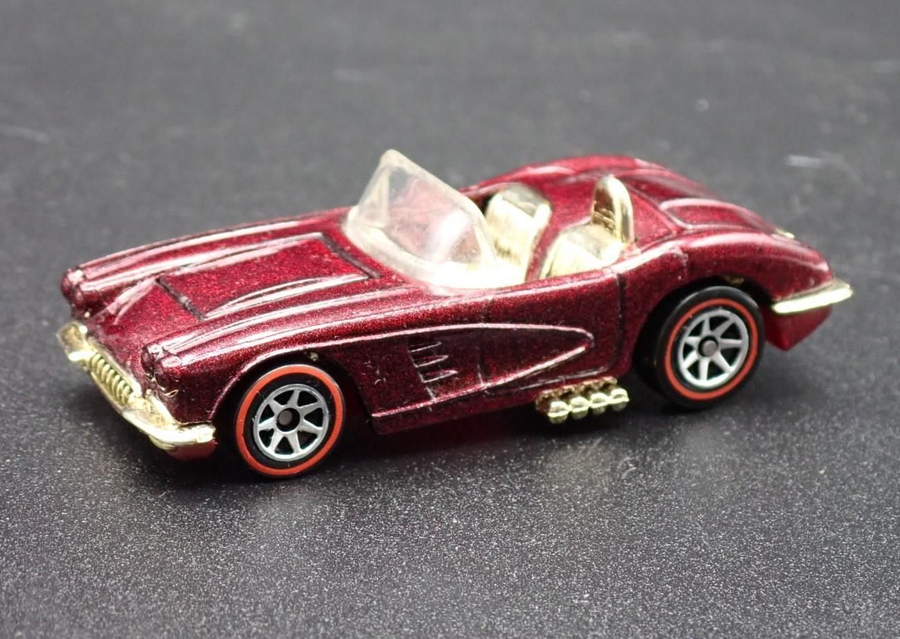 Red toy convertible car with gold accents on a dark surface