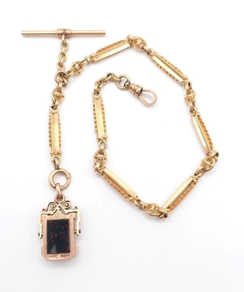 Gold chain necklace with a rectangular black pendant and T-bar clasp on a white background