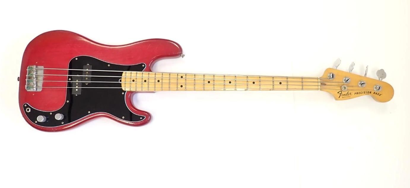 Red electric bass guitar on a white background