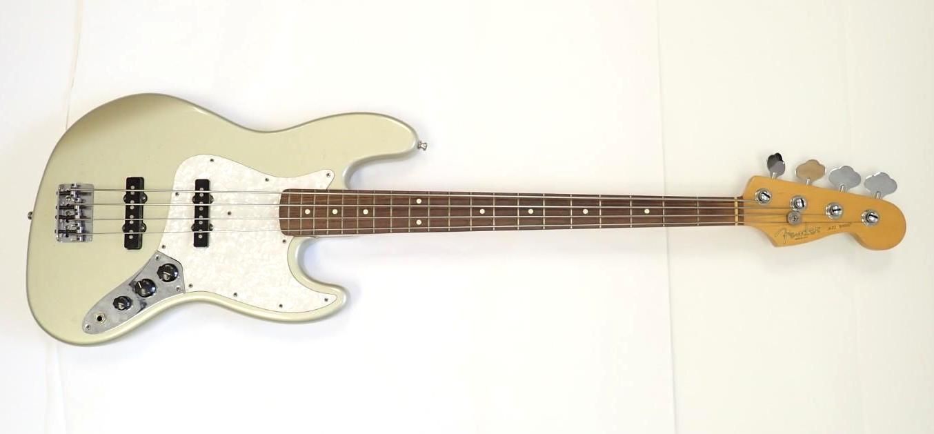 Cream-colored electric bass guitar with a wooden neck on a white background