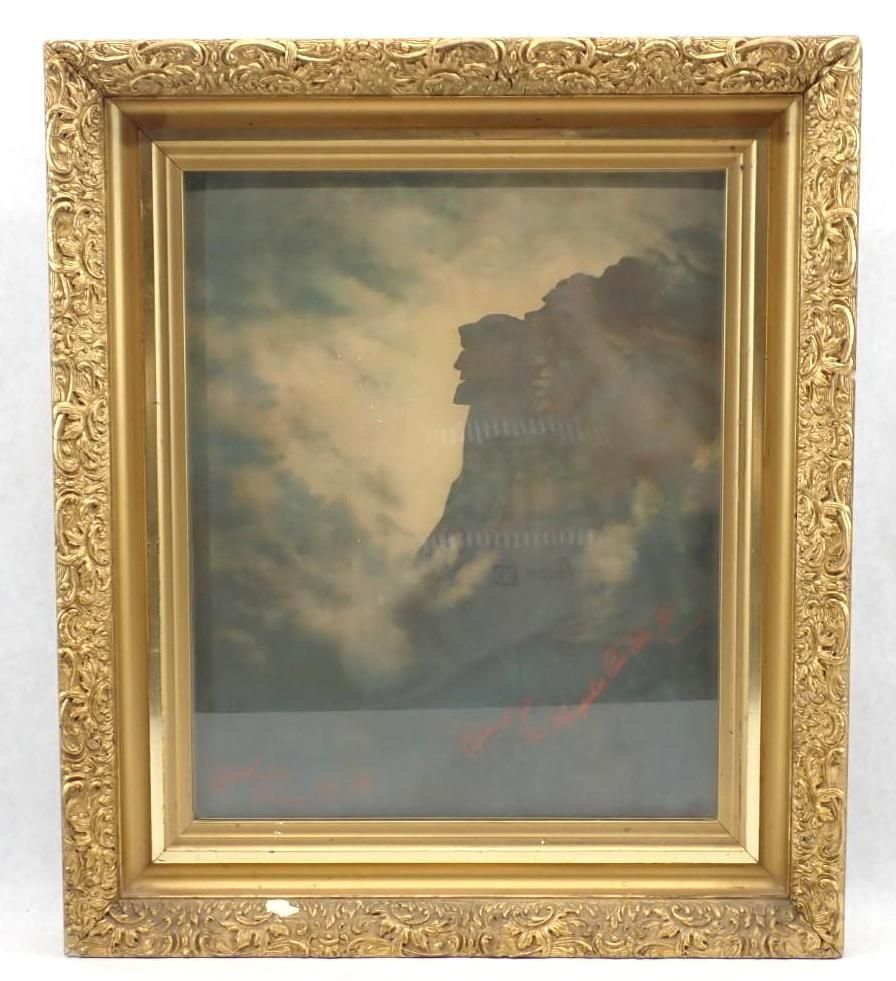 Framed painting of a cloudy sky and dark rocky cliff with a faint red streak near the bottom