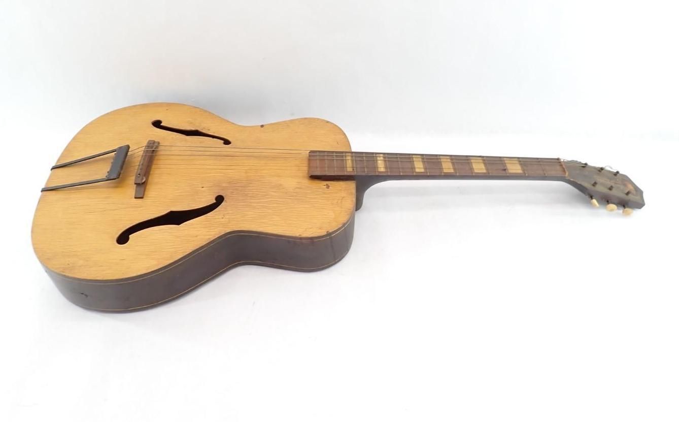 Acoustic guitar with a cutaway body and long neck, lying on a white background.