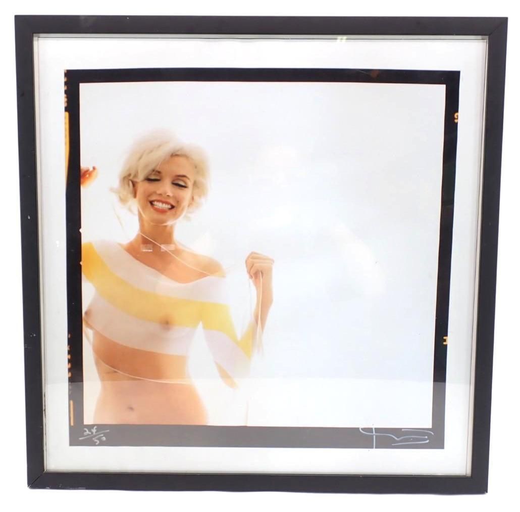 Framed photo of a smiling person in a sheer striped top with a raised fist on a bright white background
